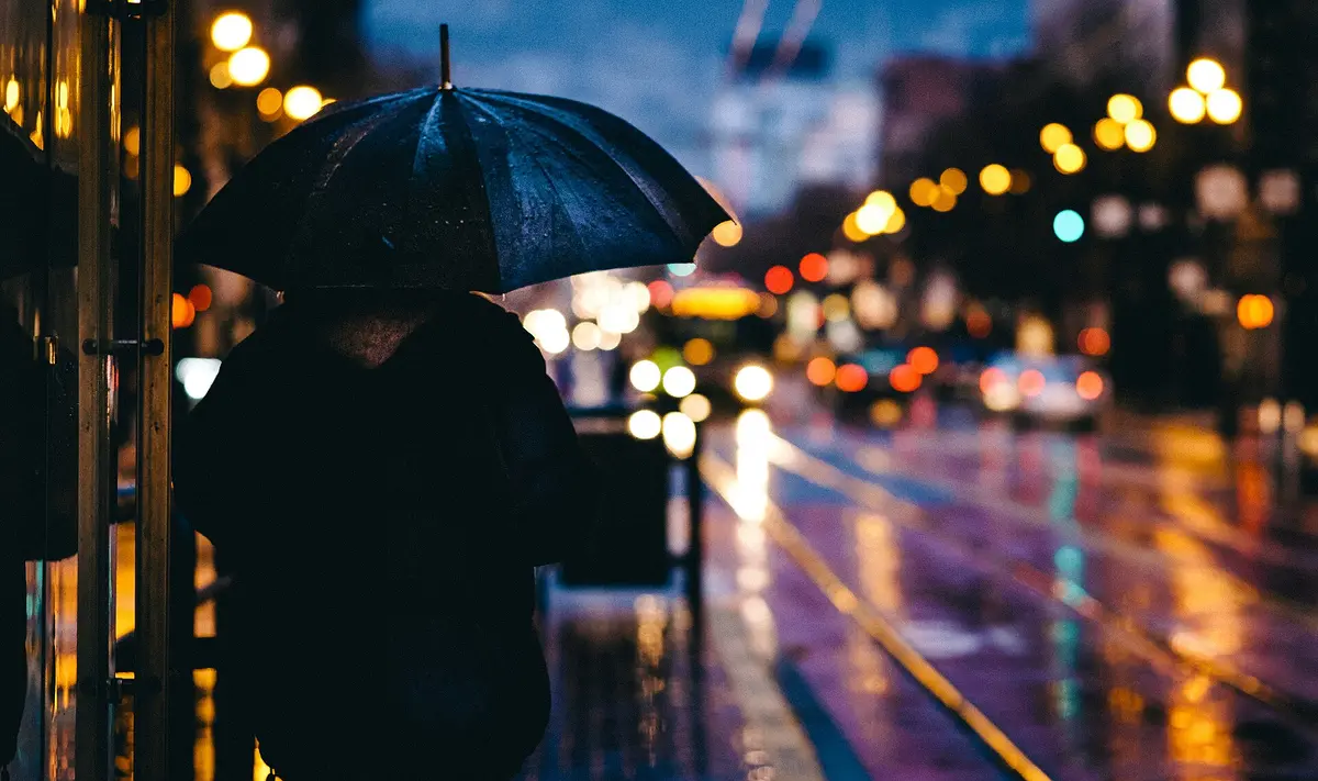 An umbrella on a lit street on a wet night